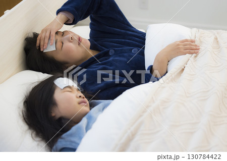 熱を出した小学生の女の子とお母さん　 130784422