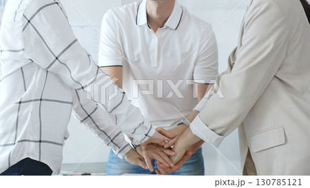 Business people joining hands together, demonstrating their strong teamwork and collaboration in achieving shared goals Business people joining hands together, demonstrating their strong teamwork and collaboration in achieving shared goals 130785121