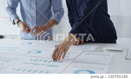 Professional business team analyzing financial reports, sharing insights and planning strategic decisions in modern workplace setting Professional business team analyzing financial reports, sharing insights and planning strategic decisions in modern workplace setting 130785180