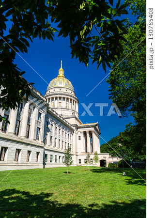 West Virginia State Capitol building in Charleston, West Virginia, United States. Designed by architect Cass Gilbert, the landmark is noted for its 23-karat gold-leaf dome, seen here framed by tree West Virginia State Capitol building in Charleston, West Virginia, United States. Designed by architect Cass Gilbert, the landmark is noted for its 23-karat gold-leaf dome, seen here framed by tree 130785408