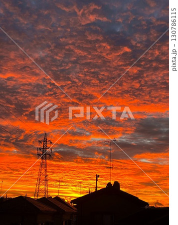 燃えるような赤に染まる夕焼け空と街のシルエット 燃えるような赤に染まる夕焼け空と街のシルエット 130786115