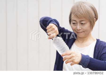 ペットボトルのキャップを開けるシニア女性 ペットボトルのキャップを開けるシニア女性 130786432