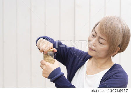 瓶の蓋を開けるシニア女性 130786457