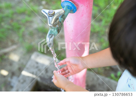 公園の水道で手を洗う女の子 130786653