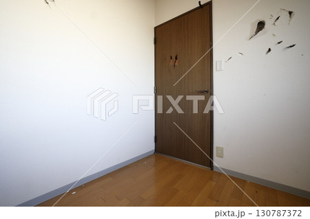 穴の開けられた壁とドア 130787372