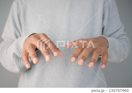 Close-Up of Hands Hovering in a Gesture Over a Neutral Background Close-Up of Hands Hovering in a Gesture Over a Neutral Background 130787960