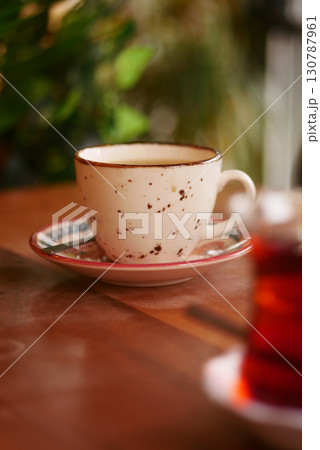 Warm cup of coffee on a rustic wooden table 130787961