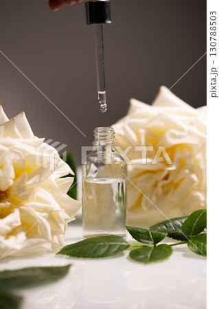 Rose Oil Dropper With Blooming Roses Showcasing Natural Beauty and Skincare Essentials Rose Oil Dropper With Blooming Roses Showcasing Natural Beauty and Skincare Essentials 130788503