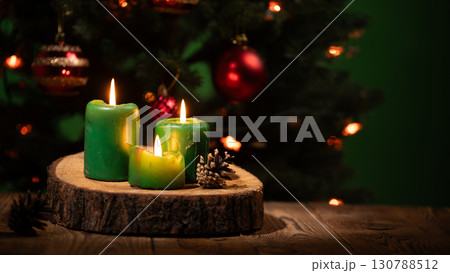 Celebrate Christmas With Flickering Green Candles on a Rustic Wooden Surface by the Festive Tree 130788512