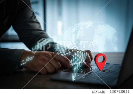Businessman using laptop with digital world map and red location pin symbol, representing global network, GPS navigation, worldwide connection, and modern technology in business. Businessman using laptop with digital world map and red location pin symbol, representing global network, GPS navigation, worldwide connection, and modern technology in business. 130788631