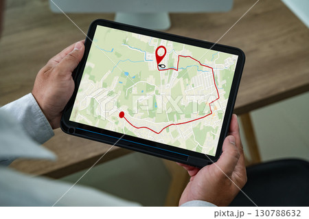 Man holding tablet with navigation app showing GPS map and route, modern digital technology for travel planning, location tracking, transportation, and online navigation guidance. 130788632