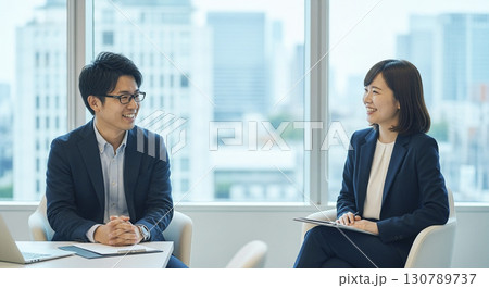 オフィスで笑顔でミーティングするビジネスパーソン 130789737