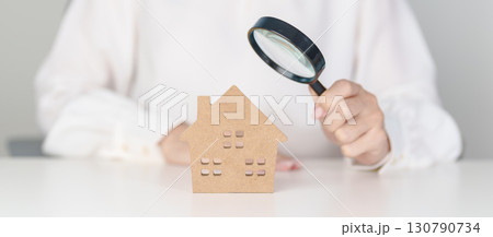 Hand hold magnifying glass over House model. mortgage, immovable assets investment, Property Inspection, Searching for real estate, purchase and rental home concept Hand hold magnifying glass over House model. mortgage, immovable assets investment, Property Inspection, Searching for real estate, purchase and rental home concept 130790734