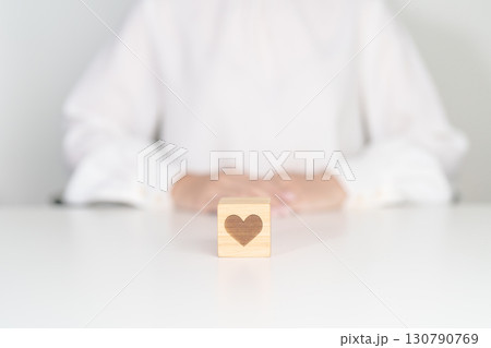 Hand holding heart block for health care, love, organ donation, charity, happy family, wellbeing and insurance concepts. world heart day, health day and mental health day Hand holding heart block for health care, love, organ donation, charity, happy family, wellbeing and insurance concepts. world heart day, health day and mental health day 130790769