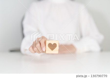 Hand holding heart block for health care, love, organ donation, charity, happy family, wellbeing and insurance concepts. world heart day, health day and mental health day Hand holding heart block for health care, love, organ donation, charity, happy family, wellbeing and insurance concepts. world heart day, health day and mental health day 130790770