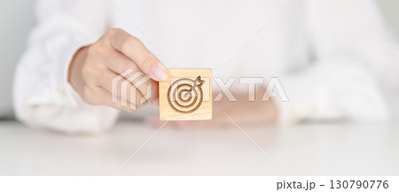 hand hold dartboard block with business goal, strategy, target, mission, action, objective, aim and success concept hand hold dartboard block with business goal, strategy, target, mission, action, objective, aim and success concept 130790776