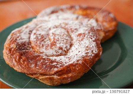 Traditional Mallorcan ensaimada pastry with powdered sugar on plate 130791827