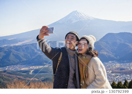 富士山を背景に笑顔で自撮りする若いカップルの観光シーン 130792399