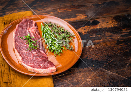 Uncooked sirloin cut, raw beef steak known for its tenderness and robust flavor. wooden background. top view 130794021