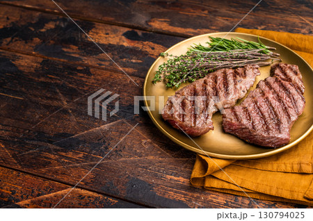 Juicy Denver, chuck eye steak, expertly grilled to perfection, offering a mouthwatering aroma and a deliciously charred exterior. wooden background. top view 130794025