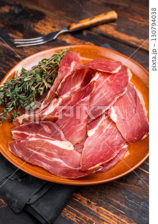 Tyrolean raw ham Speck, Italian sliced cured pork meat. wooden background. top view 130794038