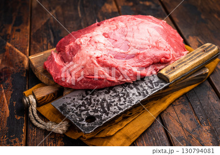 Fresh raw boneless beef shank displayed on a wooden cutting board, showcasing its rich color and marbling, perfect for hearty soups and stews. wooden background. top view 130794081