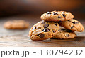 Stack of delicious chocolate chip cookies resting on wooden table 130794232