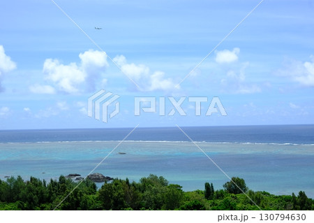 飛行機飛ぶ石垣島の珊瑚礁の海風景 130794630