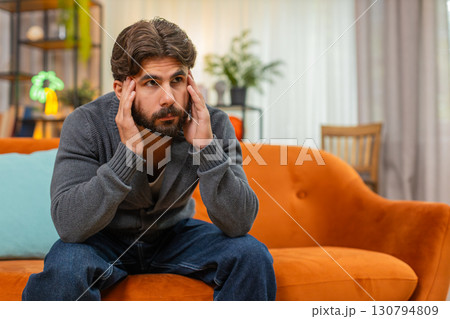 Indian man with head in hands bends forward shows strong emotional fatigue stress burnout tired mood 130794809