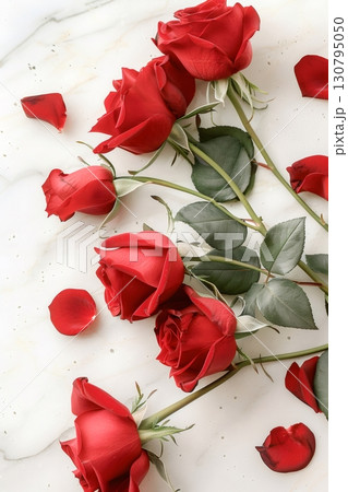 Red roses and petals lying on white marble table 130795050