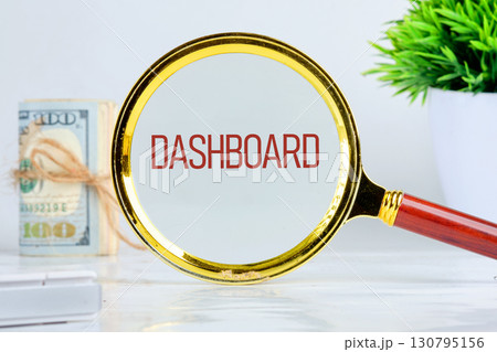 DASHBOARD word showed through a magnifying glass on a light background. Analyst working with Financial Report and Business Analytics concept 130795156