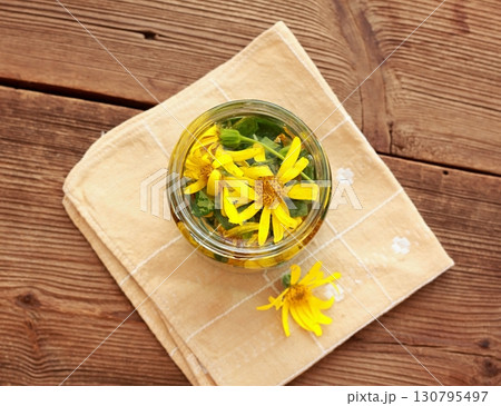 Preparation of tincture from Arnica montana, also known as wolf's bane, leopard's bane  and mountain arnica. 130795497
