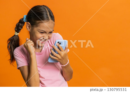 Child girl kid use mobile smartphone browsing say Wow yes found out great win good news celebrate Child girl kid use mobile smartphone browsing say Wow yes found out great win good news celebrate 130795531