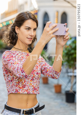 Caucasian woman blogger using smartphone taking photography pictures of old city buildings outdoors Caucasian woman blogger using smartphone taking photography pictures of old city buildings outdoors 130795821