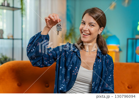 Happy woman real estate agent lifting hand showing the keys of new home buying or renting property 130796094