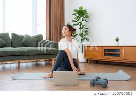 Young Asian woman stretching yoga workout on exercise mat 130796502