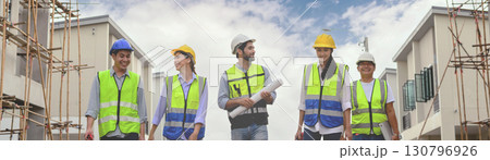 Group of happy contractors, engineers and formats in safety vests with helmets stand on the under-construction building site. teamwork concept. 130796926