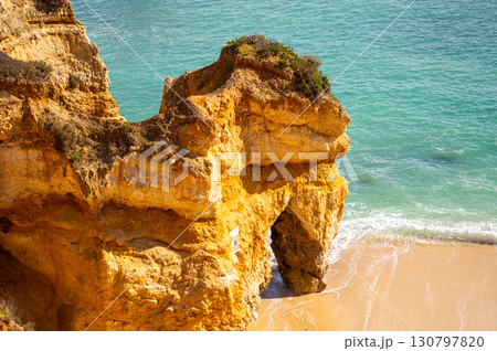 View of idyllic nature landscape with rocky cliff shore and waves crashing on. Rocks near Sagres. West Atlantic coast of Algarve region, south of Portugal. View of idyllic nature landscape with rocky cliff shore and waves crashing on. Rocks near Sagres. West Atlantic coast of Algarve region, south of Portugal. 130797820