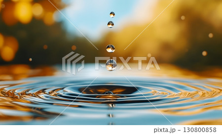 A close up view of a single water drop creating a captivating splash with its rippling reflections on the surface revealing a serene and harmonious natural beauty 130800858