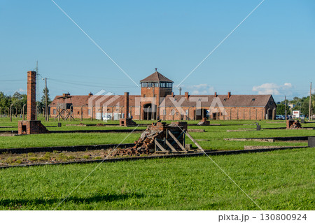Auschwitz Birkenau Concentration and Extermination Camp. Barracks chimneys in front of the entrance gate Auschwitz Birkenau Concentration and Extermination Camp. Barracks chimneys in front of the entrance gate 130800924