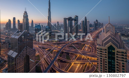 Dubai downtown skyline with tallest skyscrapers and busiest traffic on highway intersection night to day timelapse Dubai downtown skyline with tallest skyscrapers and busiest traffic on highway intersection night to day timelapse 130802797