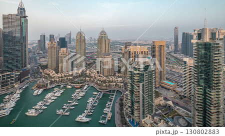 Aerial top view of Dubai Marina day to night timelapse. Modern towers and traffic on the road 130802883