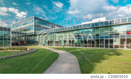 Modern low rise glass office building in business district and green lawn in inner yard timelapse hyperlapse 130803010