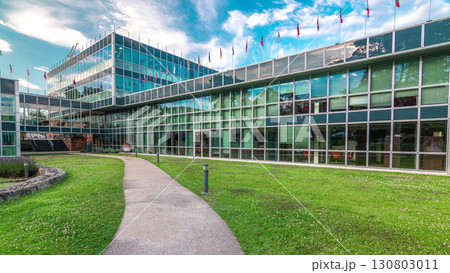 Modern low rise glass office building in business district and green lawn in inner yard timelapse hyperlapse 130803011
