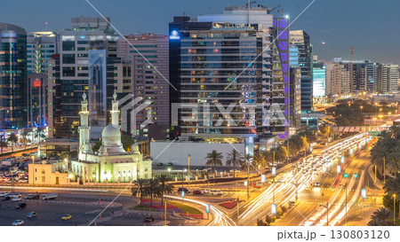 Mosque near Dubai Creek surrounded by modern buildings and busy traffic street day to night timelapse Mosque near Dubai Creek surrounded by modern buildings and busy traffic street day to night timelapse 130803120