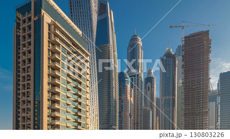 View of modern skyscrapers shining in sunrise lights timelapse in Dubai Marina in Dubai, UAE. View of modern skyscrapers shining in sunrise lights timelapse in Dubai Marina in Dubai, UAE. 130803226