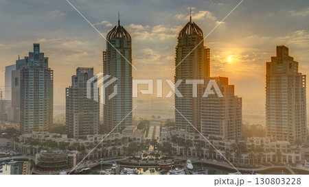 View of modern skyscrapers shining in sunrise lights timelapse in Dubai Marina in Dubai, UAE. 130803228