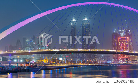 Pedestrian Bridge over the Dubai Water Canal day to night timelapse, United Arab Emirates 130803499