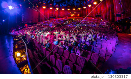 Spectators gather in the auditorium and watch the show in theatre timelapse. Large hall with red armchairs seats 130803517
