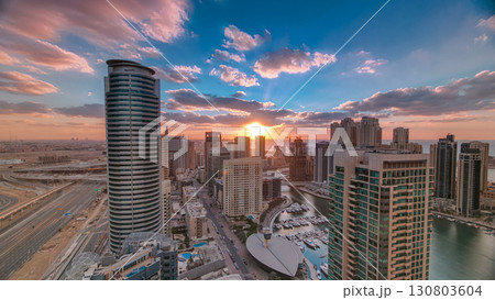 Modern skyscrapers and water channel with boats of Dubai Marina at sunset timelapse, United Arab Emirates. 130803604